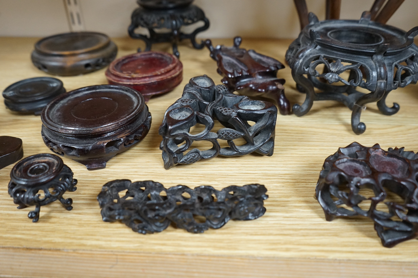 A collection of fifteen Chinese and Japanese carved hardwood stands, tallest 15.5cm. Condition - fair to good